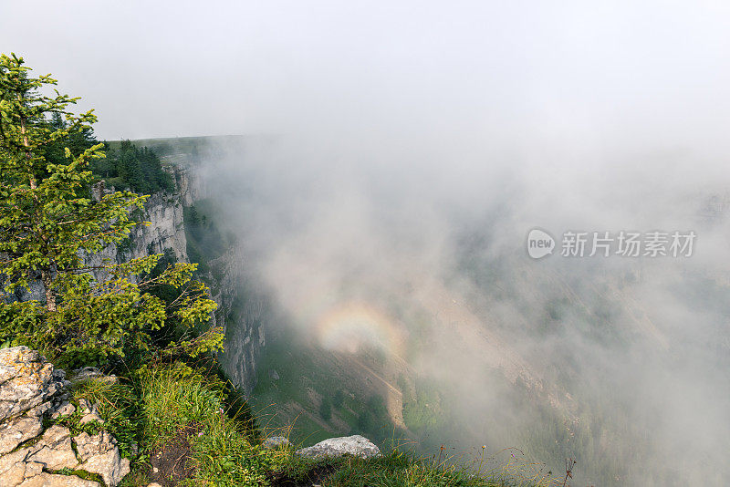 雾和瑞士汝拉山脉Creux du Van峡谷中的小彩虹